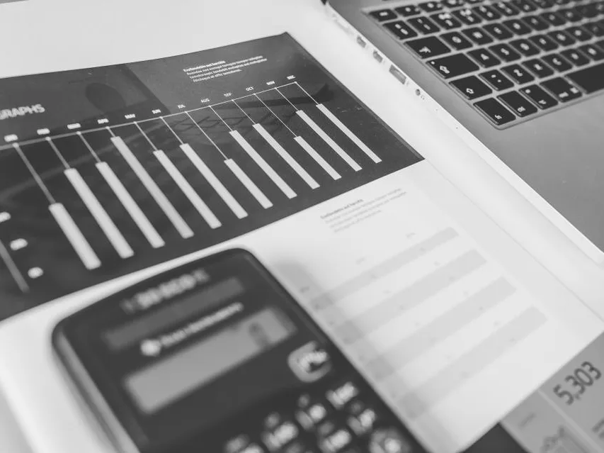 Gráficos financieros impresos junto a una calculadora